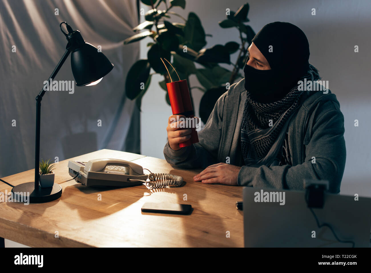 Terrorist In Mask Sitting In Room And Holding Dynamite Stock