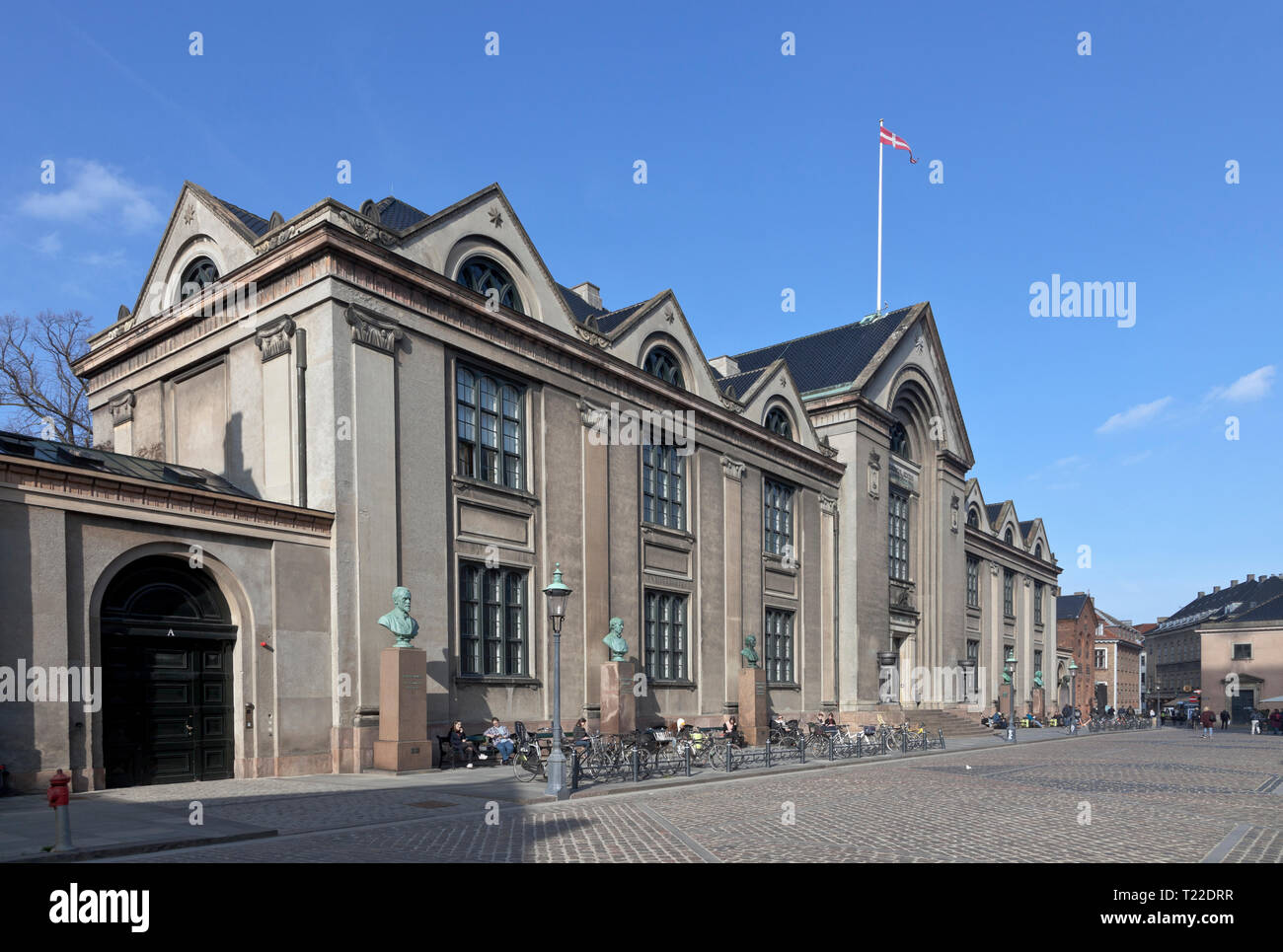 The main building of Copenhagen University at Nørregade / Vor Frue Plads in central Copenhagen, Denmark. Busts of 6 famous scientists in front. Stock Photo
