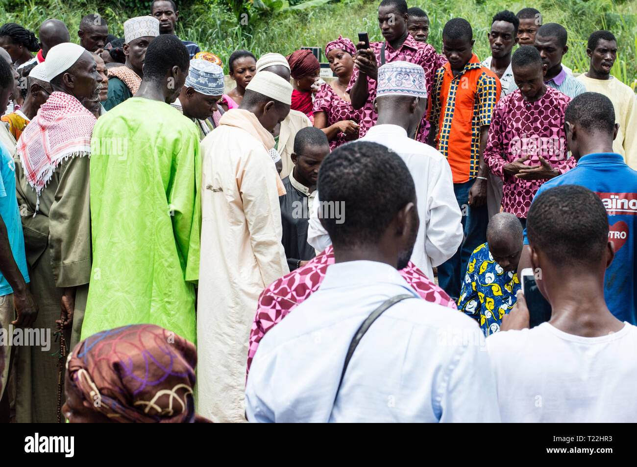 Ananguié, Côte d'Ivoire - June 10, 2017: men in boubou and hats on one side and another group of people on the side, all look down. To say a farewell  Stock Photo