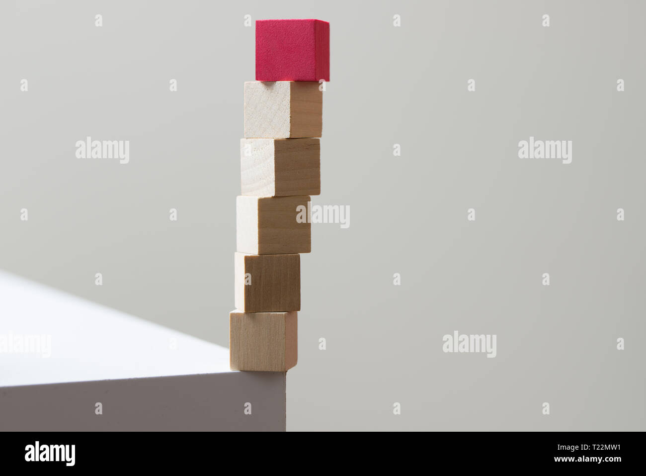 Wooden cubes in balance at the edge of the table for risk concept Stock Photo