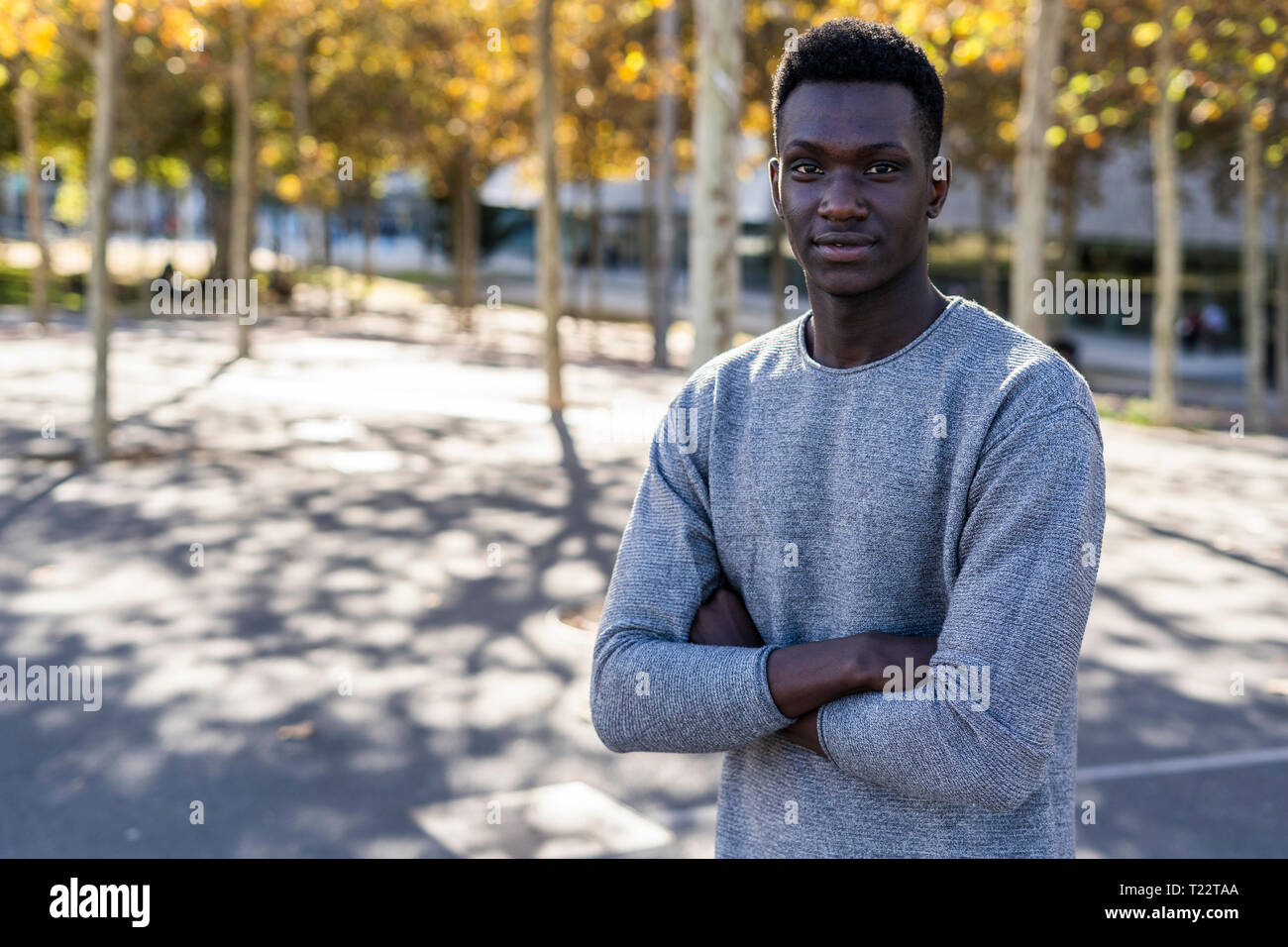Portrait of a confident young man, standing in a park Stock Photo