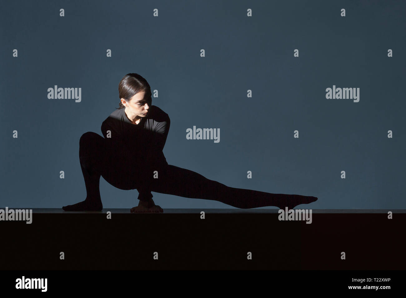 Woman dressed in black doing stretching exercise Stock Photo