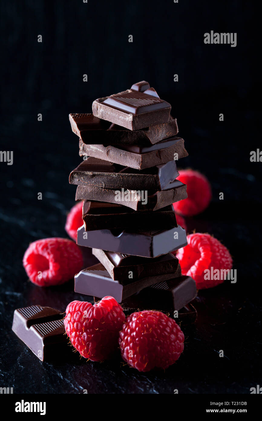 Pile of chocolate pieces and raspberries on black slate Stock Photo - Alamy
