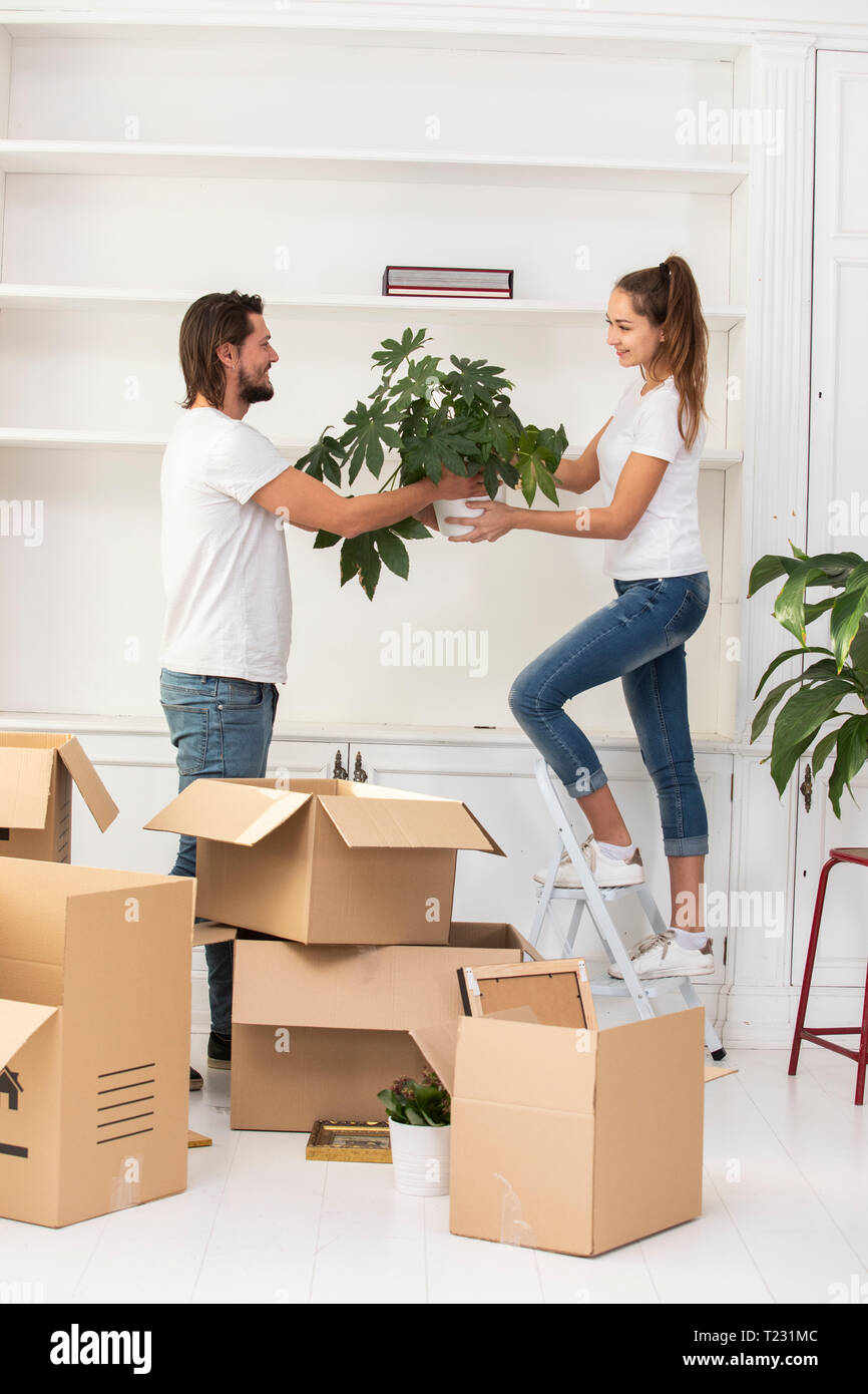 Couple unpacking cardboard boxes and furnishing new home Stock Photo