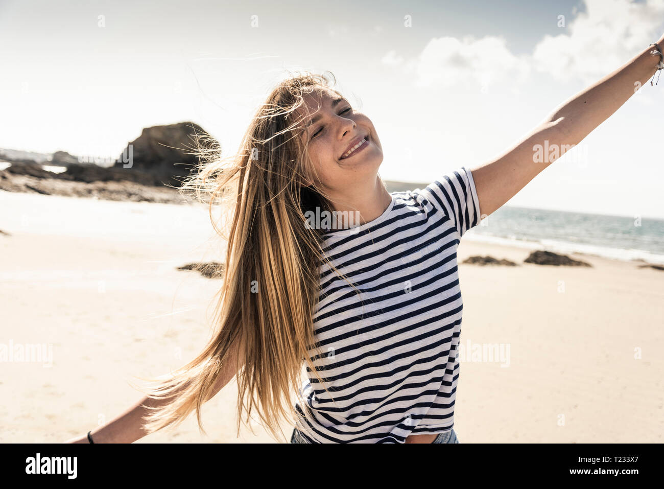 Happy young woman dancing on the beach Stock Photo - Alamy