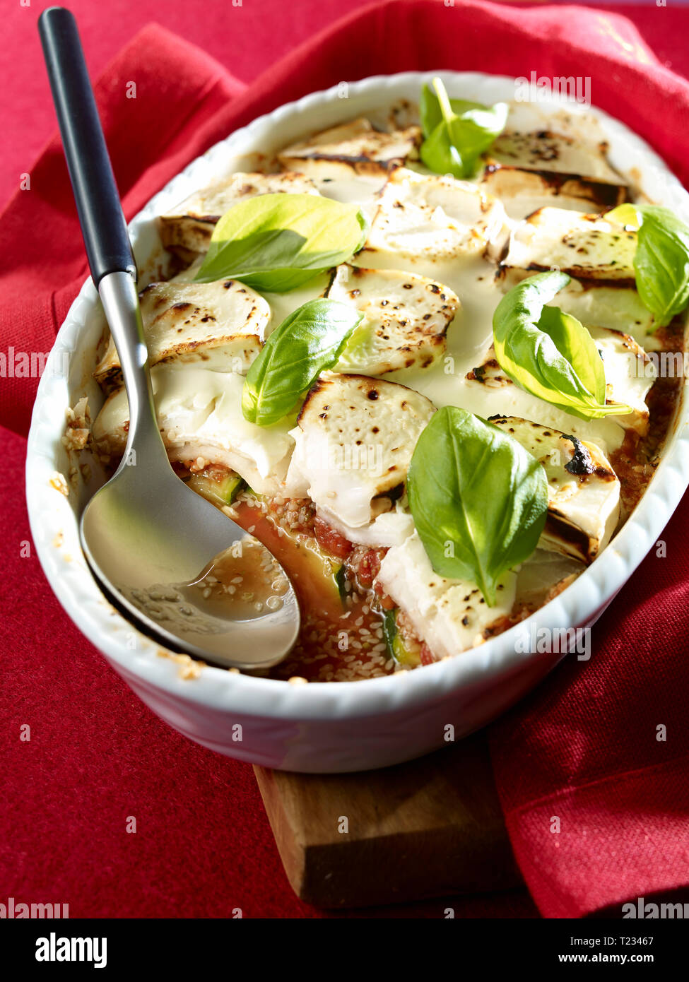 Courgette gratin with goat cheese, sesame in gratin dish, low carb Stock Photo
