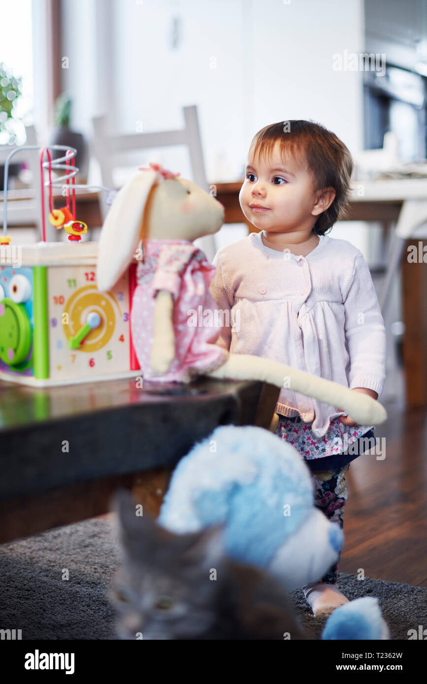 Cute baby girl playing with cuddly toy at home Stock Photo