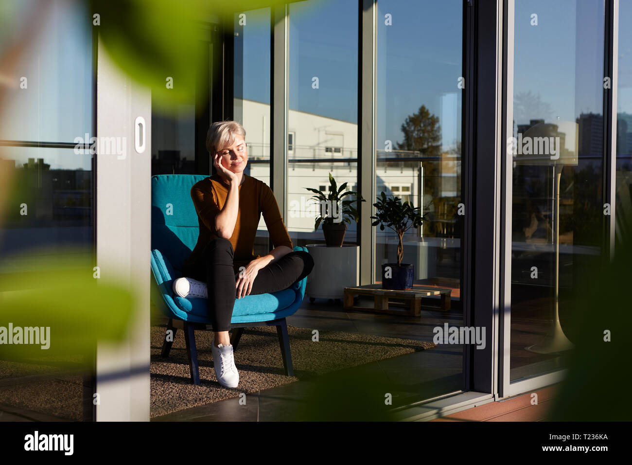 Woman sitting in armchair with closed eyes Stock Photo - Alamy