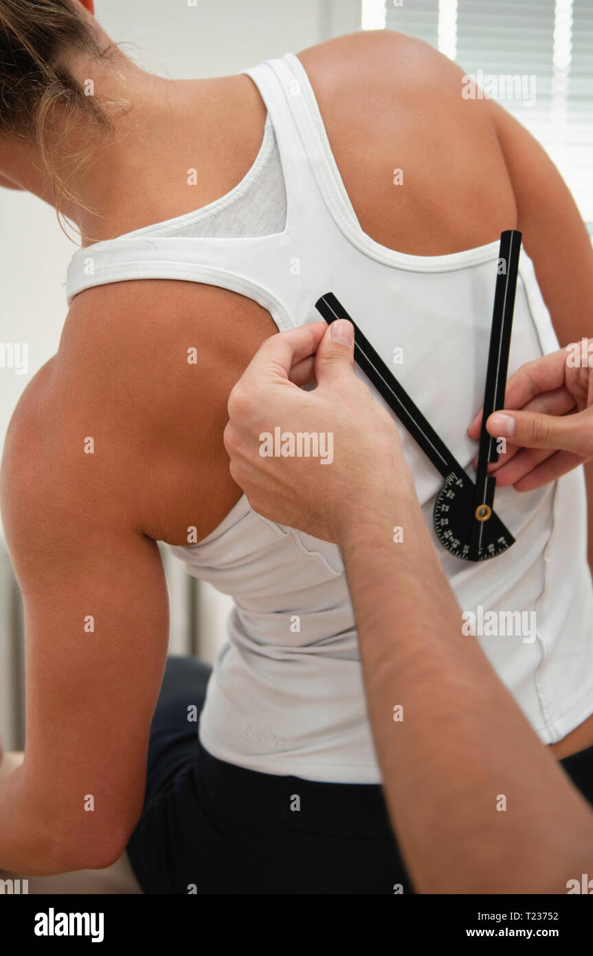 Physiotherapist measure back flexion with goniometer. Stock Photo
