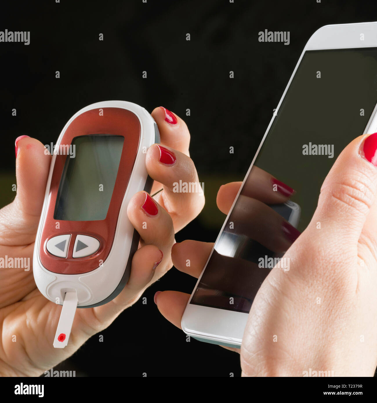 Mobile healthcare technology. Using smart phone with blood sugar testing device. Stock Photo