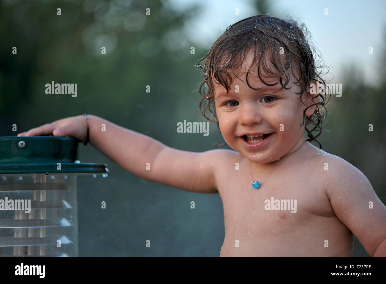 Baby getting wet on a garden in summer Stock Photo - Alamy