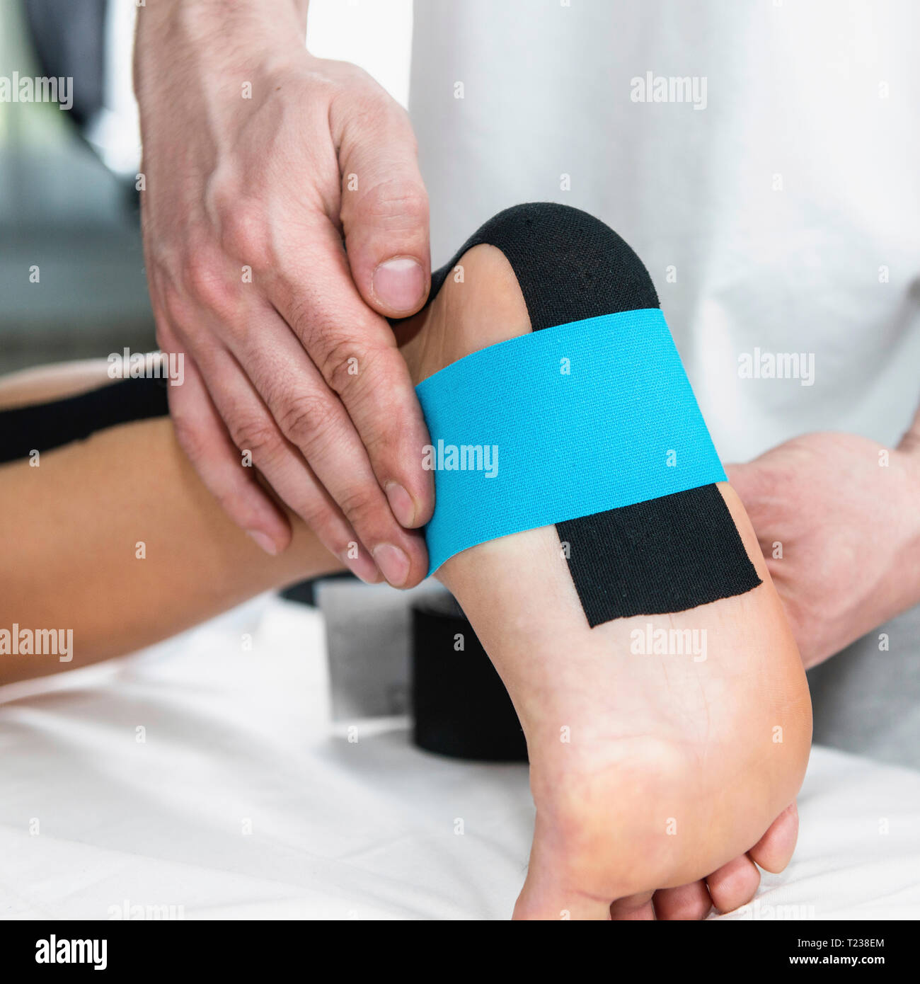 Physical therapist placing taping on patient's foot Stock Photo Alamy