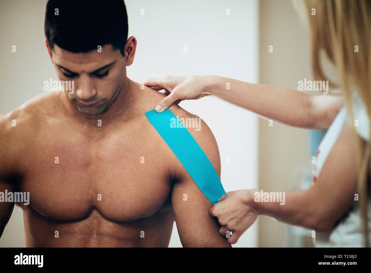Kinesio taping in physical therapy. Therapist placing kinesio tape to