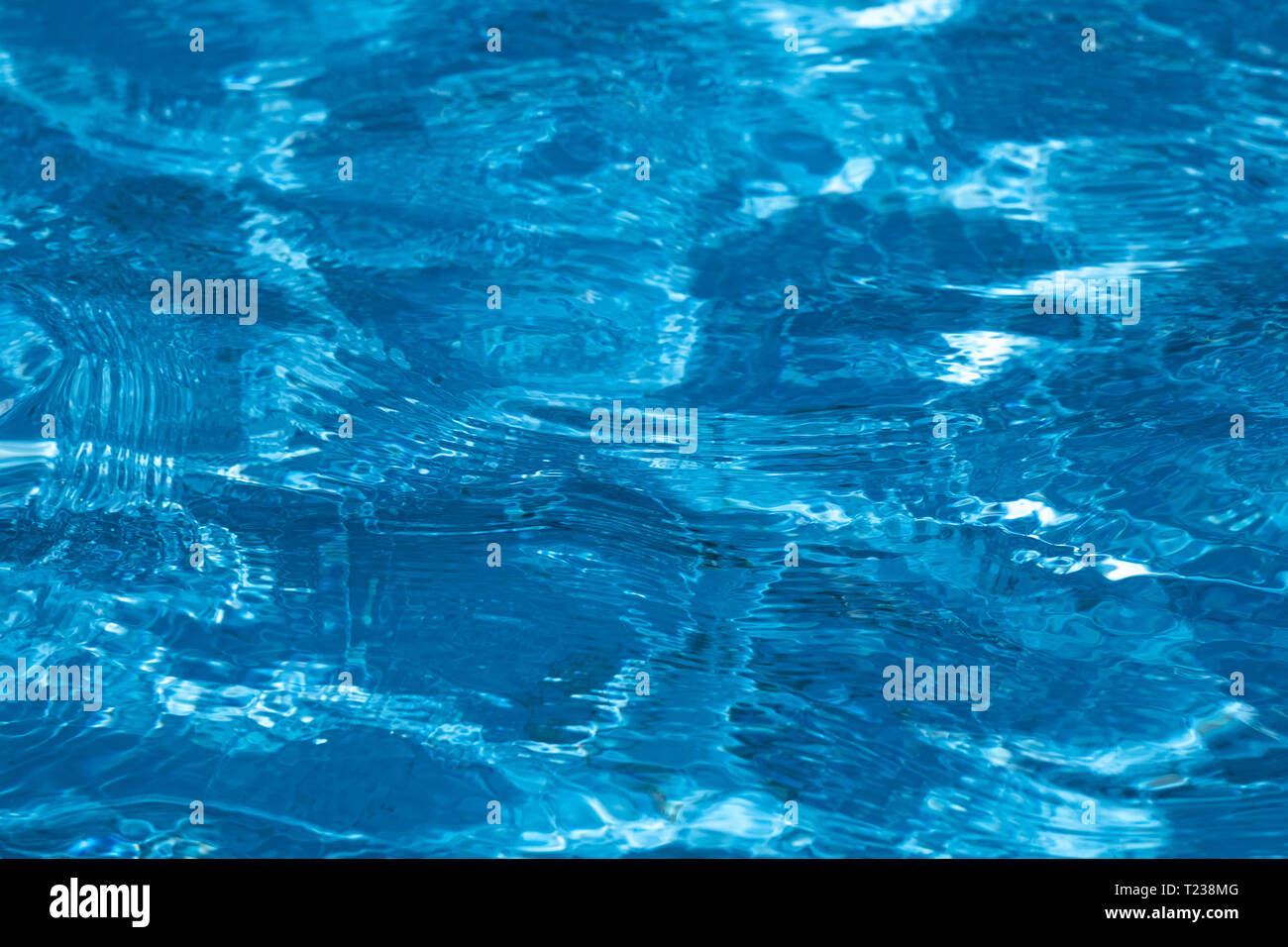 Blue and bright ripple clean water surface in swimming pool with sun ...