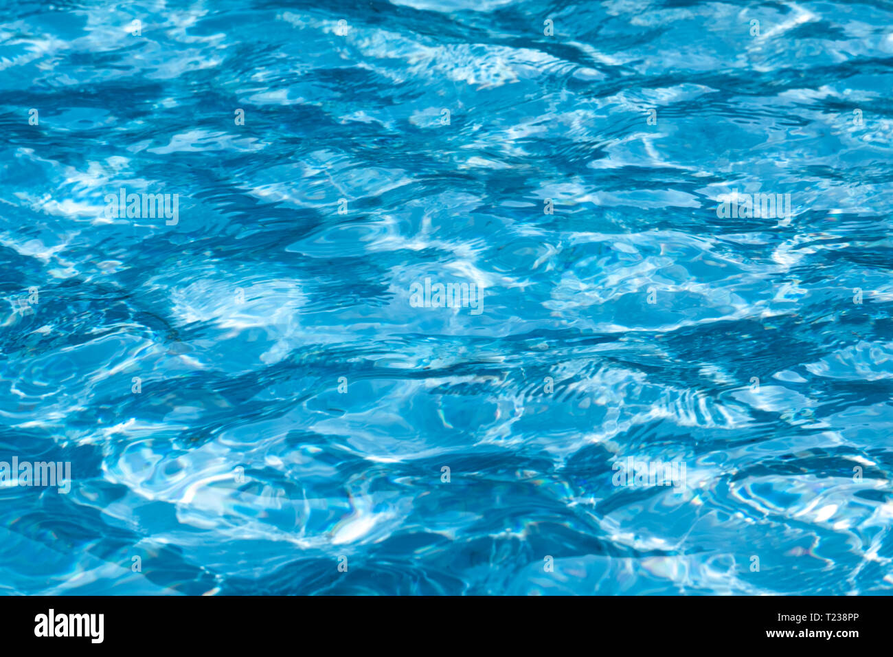Blue and bright ripple clean water surface in swimming pool with sun ...