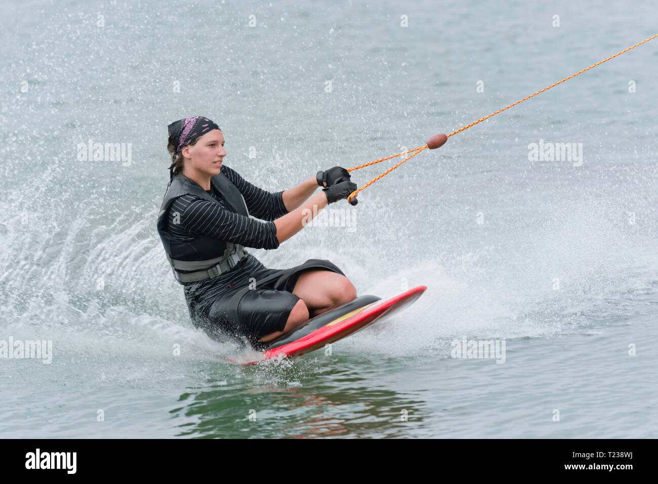 Young woman kneeboarding on lake Stock Photo Alamy