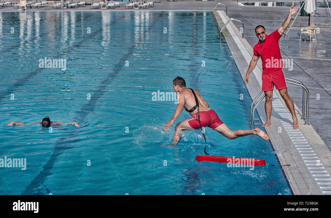 Lifeguard training course - rescuing woman from swimming pool. Stock Photo