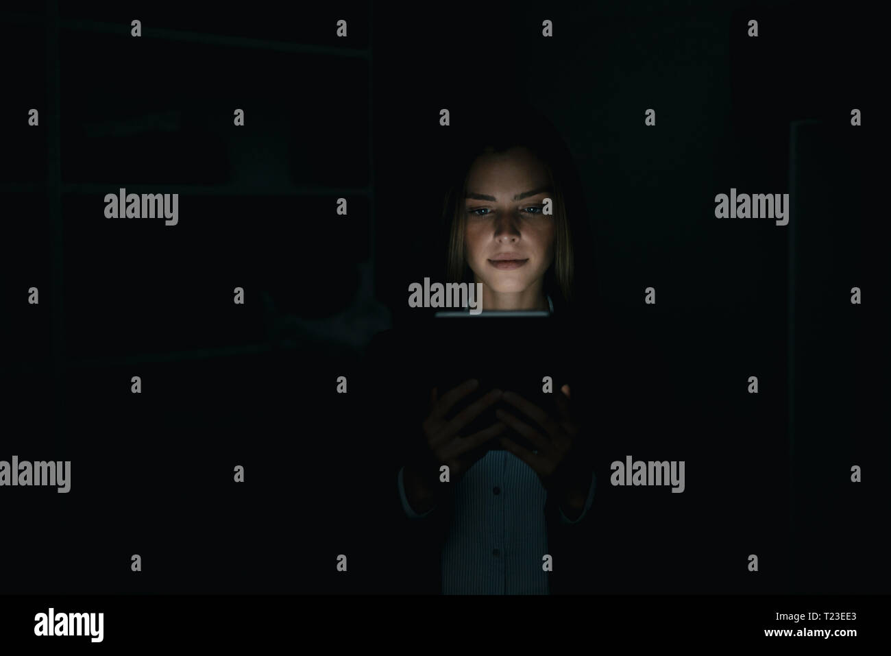 Young woman using digital tablet in he dark Stock Photo