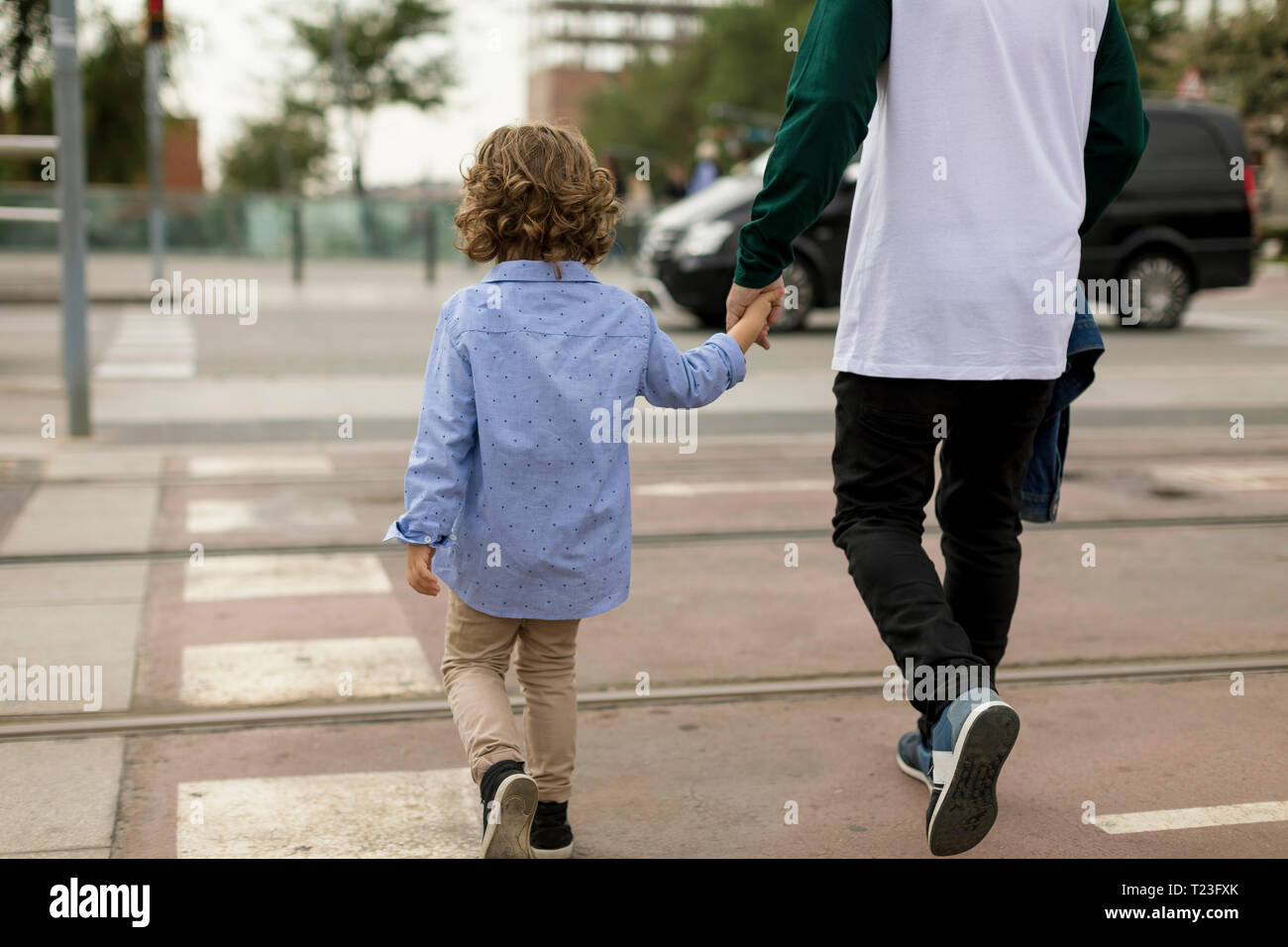 Rear view of father and son walking hand in hand in the city Stock ...