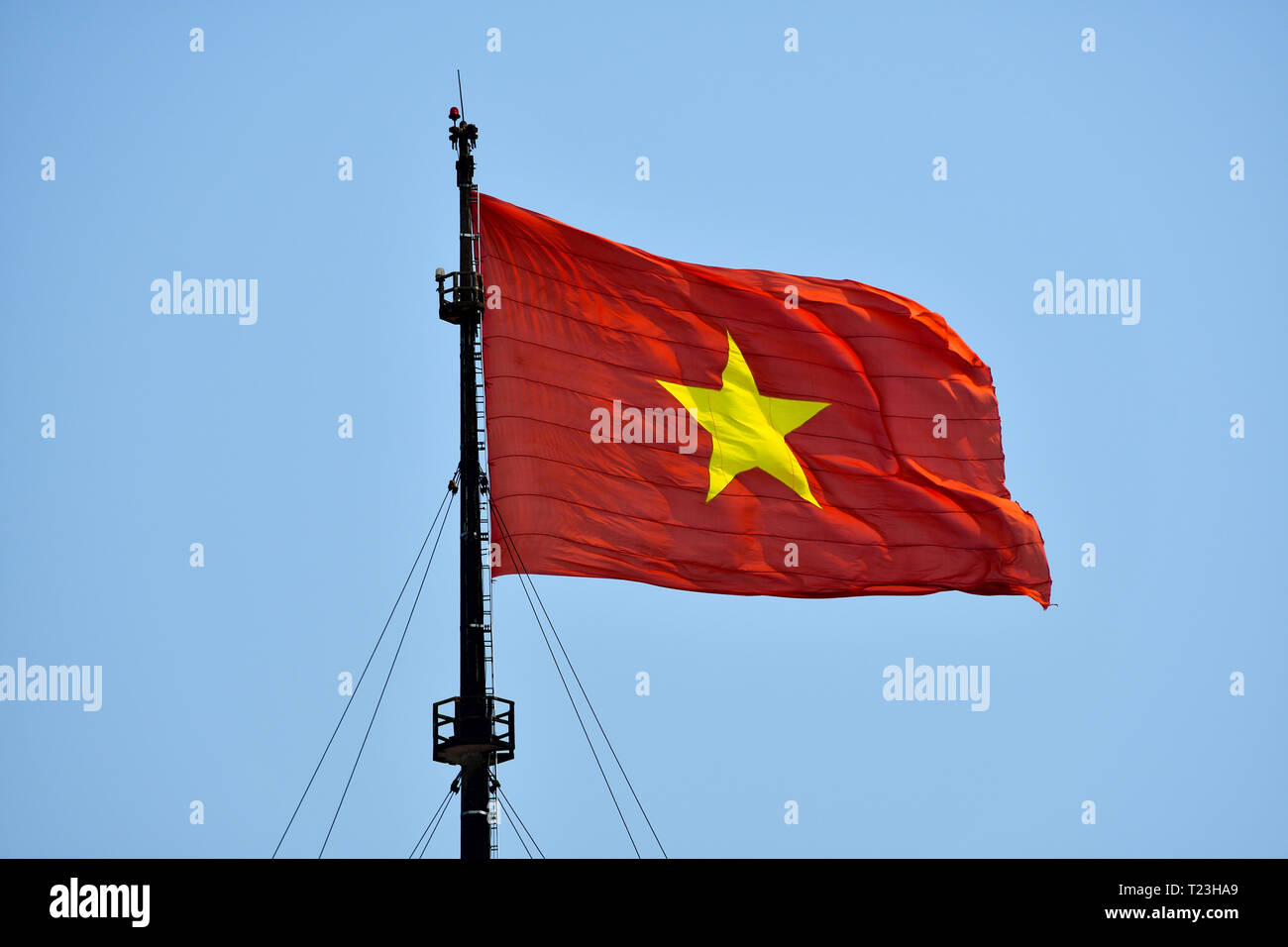 Huge Flag of Vietnam on the wind ona sunny day in Hue, Vietnam. Red flag with yellow star. Stock Photo