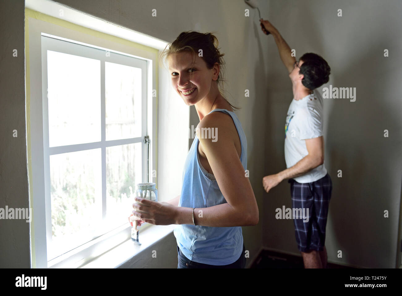Young couple renovating their home painting the wall together Stock Photo