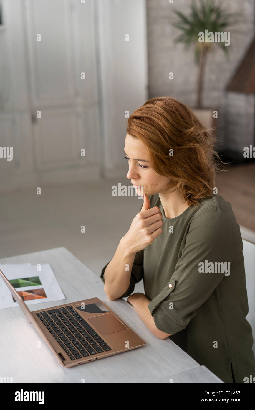 Young woman working in office, using laptop Stock Photo