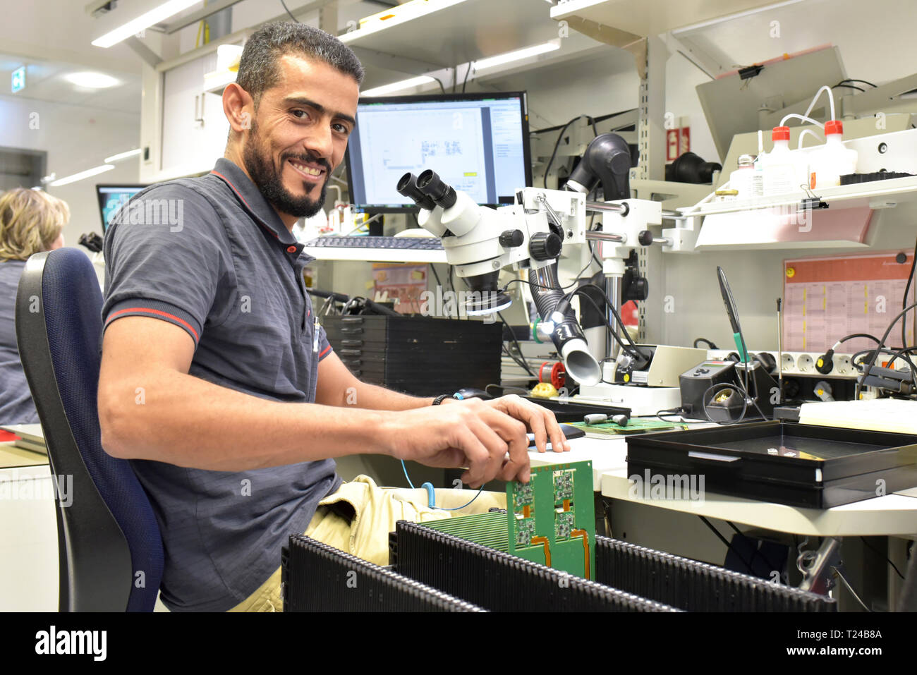 Portrait of smiling man working on quality control in the manufacturing of circuit boards for the electronics industry Stock Photo