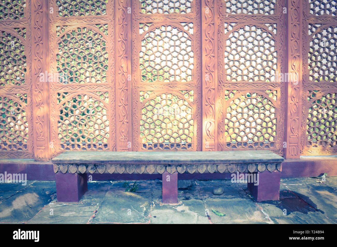 Stone bench in garden with Indian style wall Stock Photo - Alamy