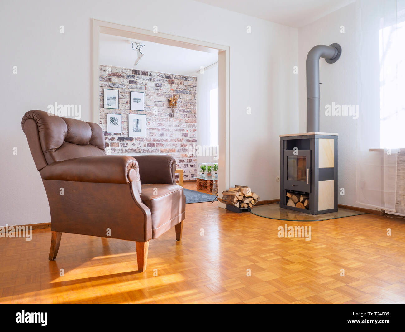 Germany, modern living room, leather chair and fireplace Stock Photo