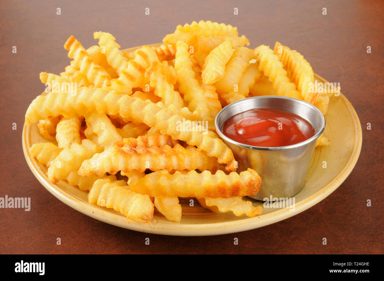 https://c8.alamy.com/comp/T24GHE/crinkle-cut-french-fries-and-a-cup-of-catsup-T24GHE.jpg