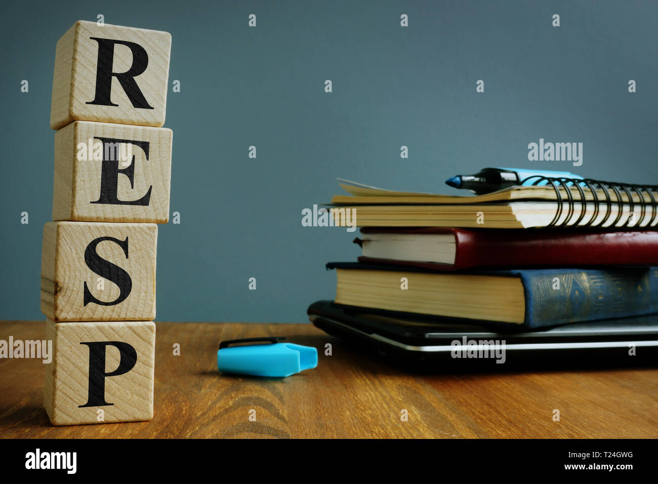 Registered Education Savings Plan RESP. Wooden cubes and notebooks. Stock Photo