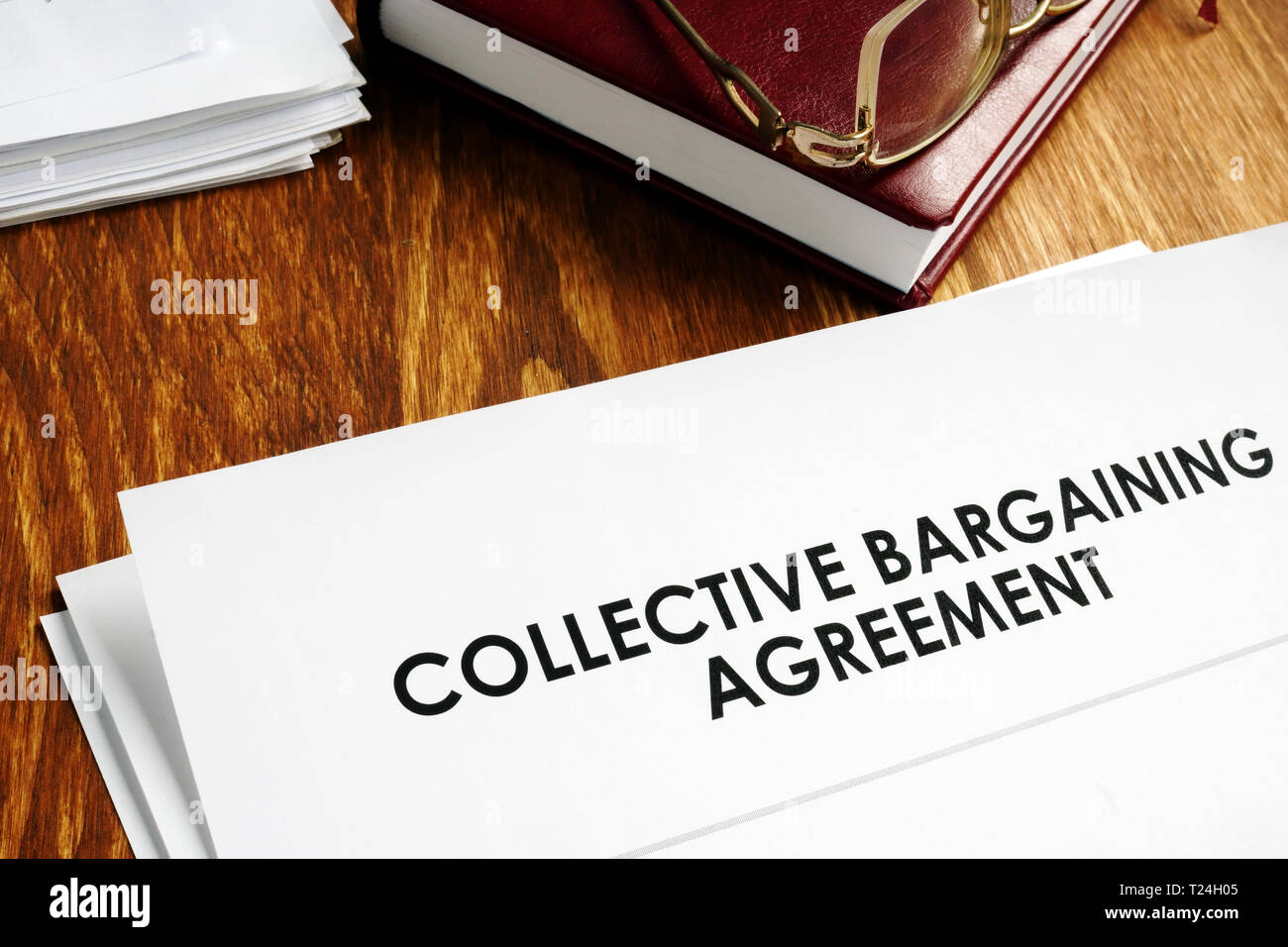 Collective bargaining agreement and note pad with glasses. Stock Photo