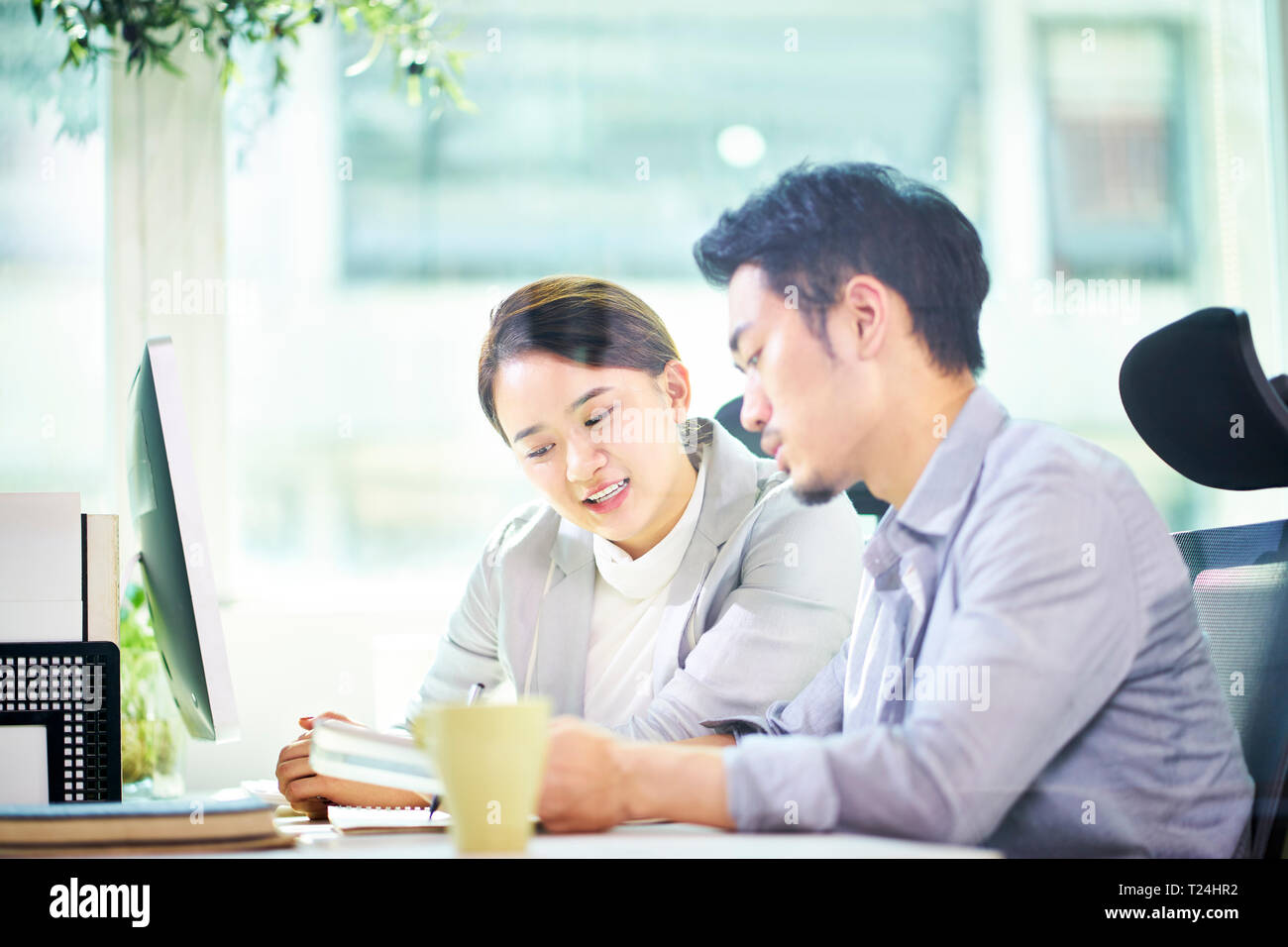 asian business man and woman working together in office using tablet PC. Stock Photo