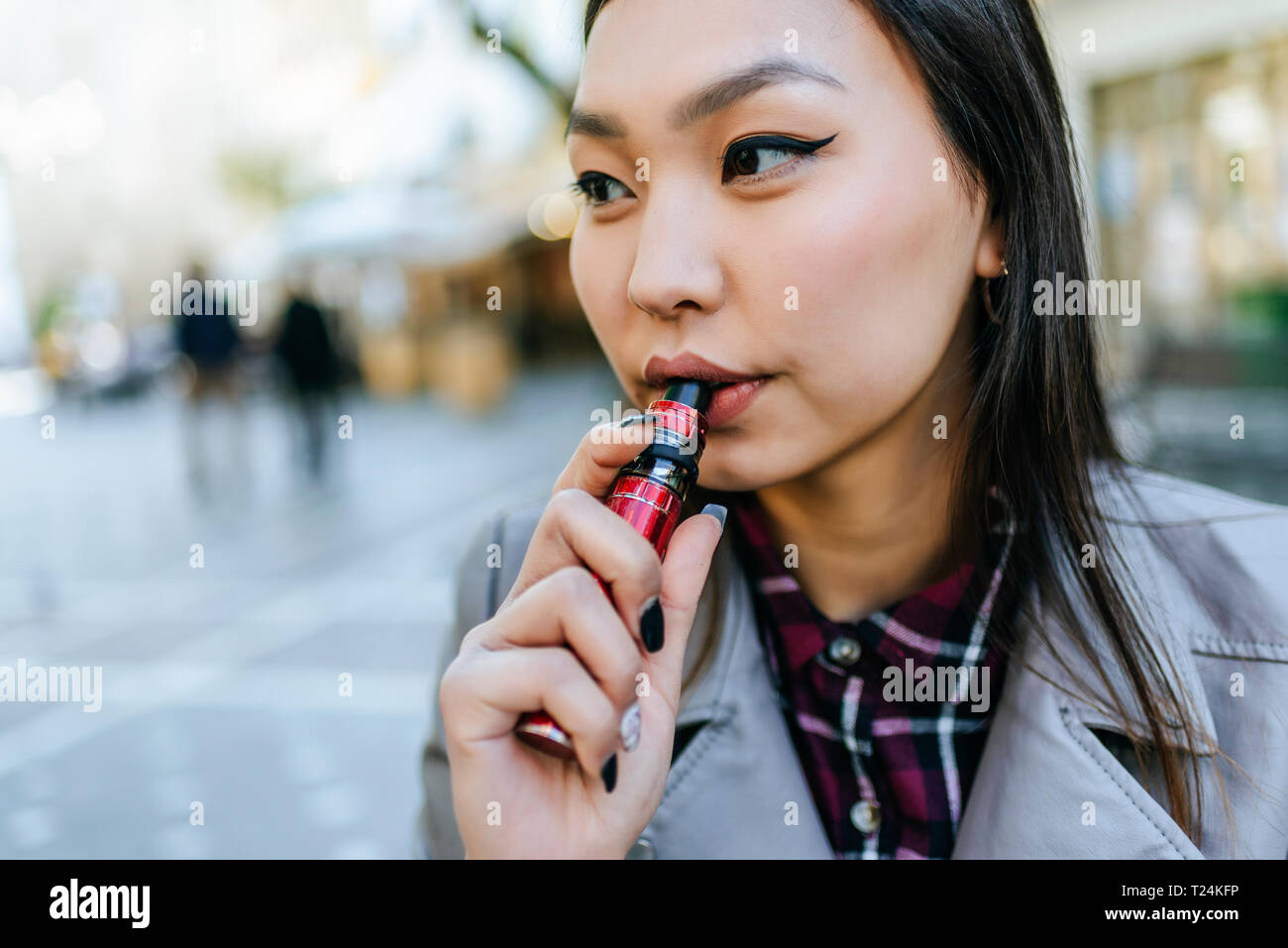 Young woman smoking electronic cigarette Stock Photo
