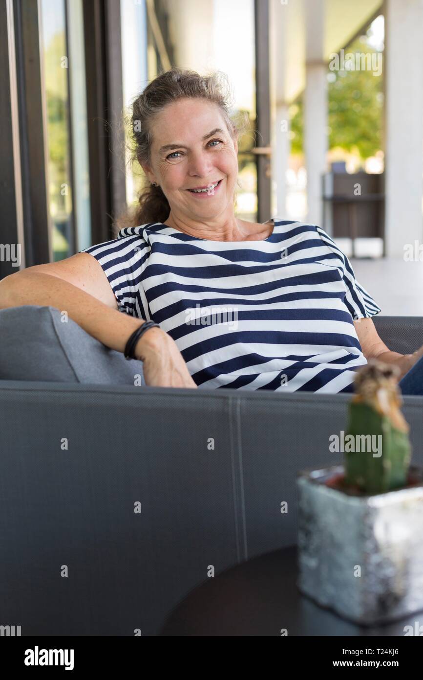 Portrait of smiling mature woman relaxing on terrace Stock Photo - Alamy