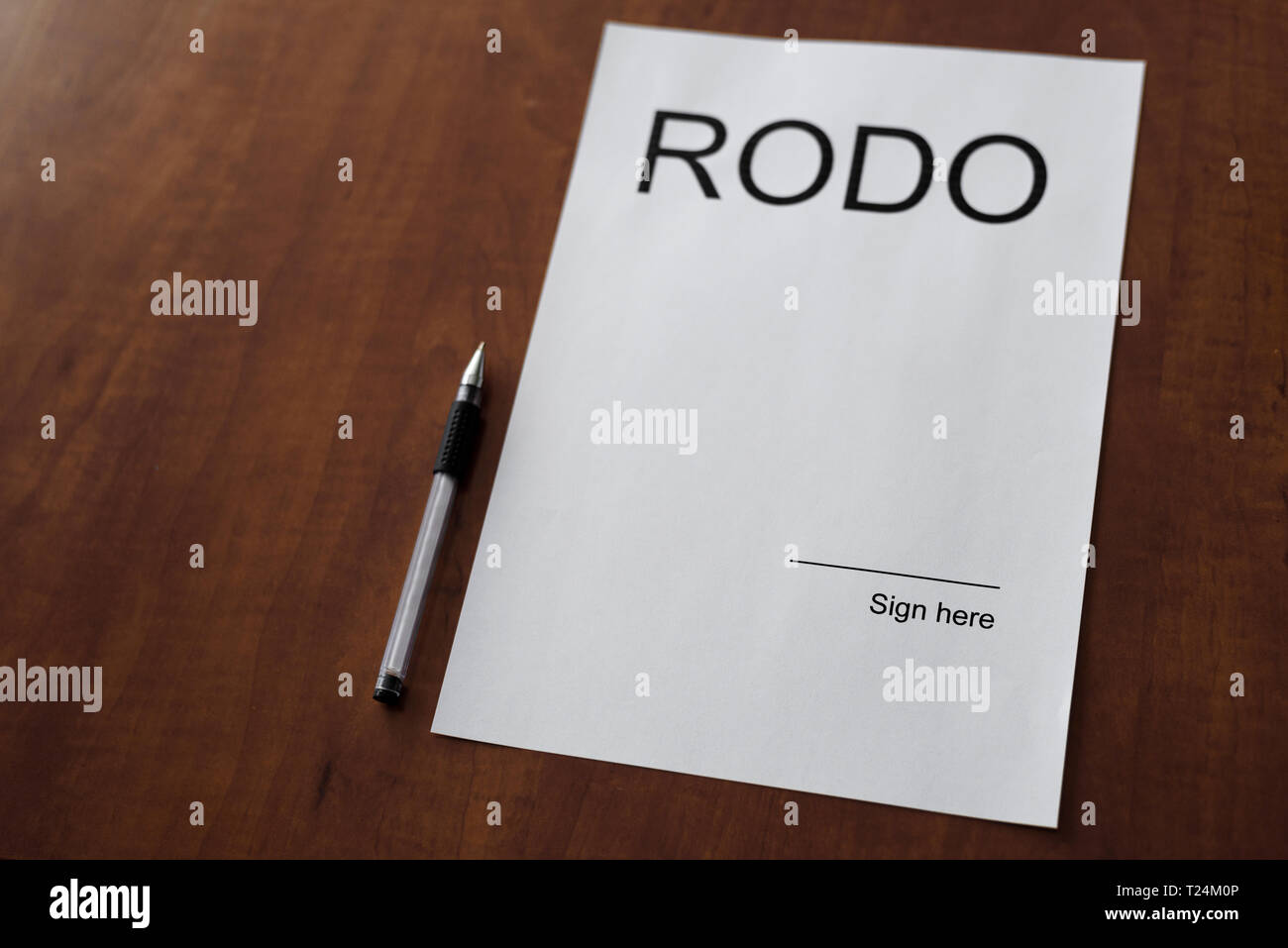 White sheet of paper on the wooden table with pen. Blank space on the paper with space to sign it with RODO word. General Data Protection Regulation - Stock Photo