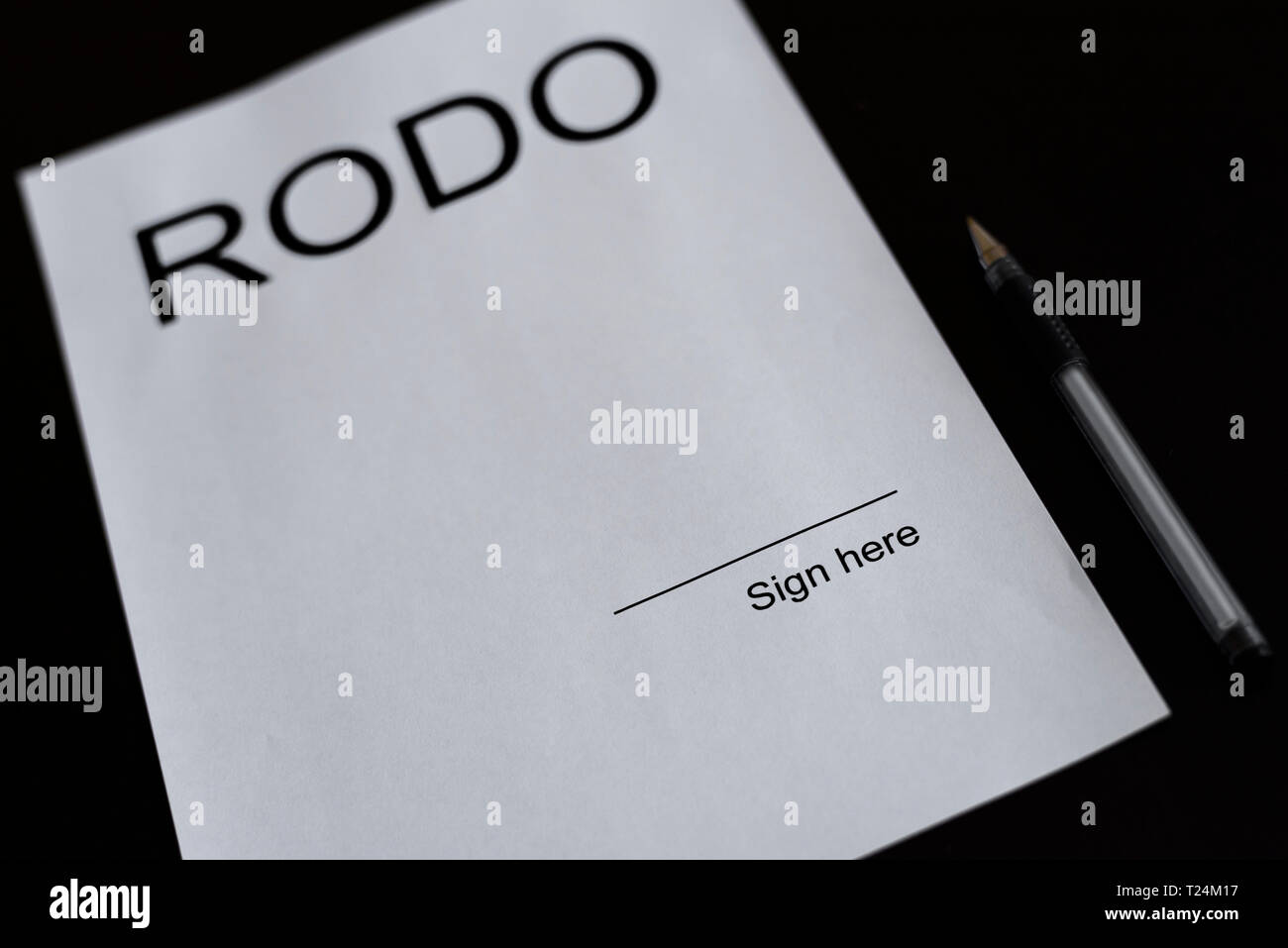 White paper on the black table with pen. Blank space on the paper with place to sign it with inscription RODO. General Data Protection Regulation - Ro Stock Photo