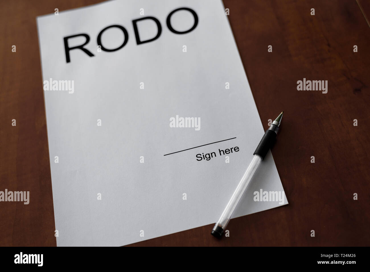 White sheet of paper on wood desk with pen. Blank space on the paper with place to sign it with word RODO. General Data Protection Regulation - Rozpor Stock Photo
