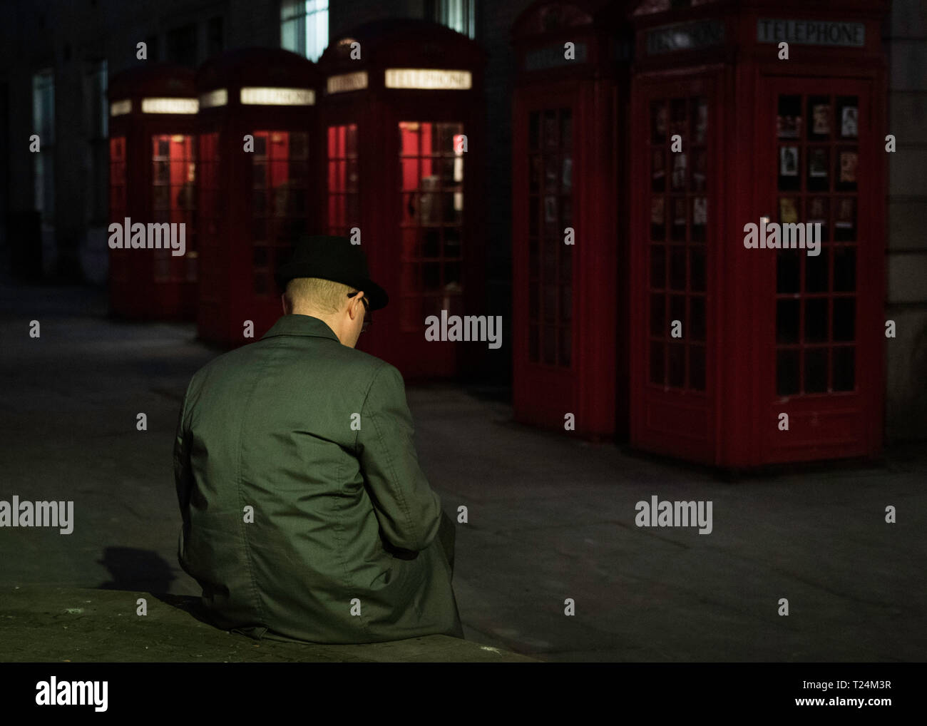 Lonely man sitting at London street at night Stock Photo