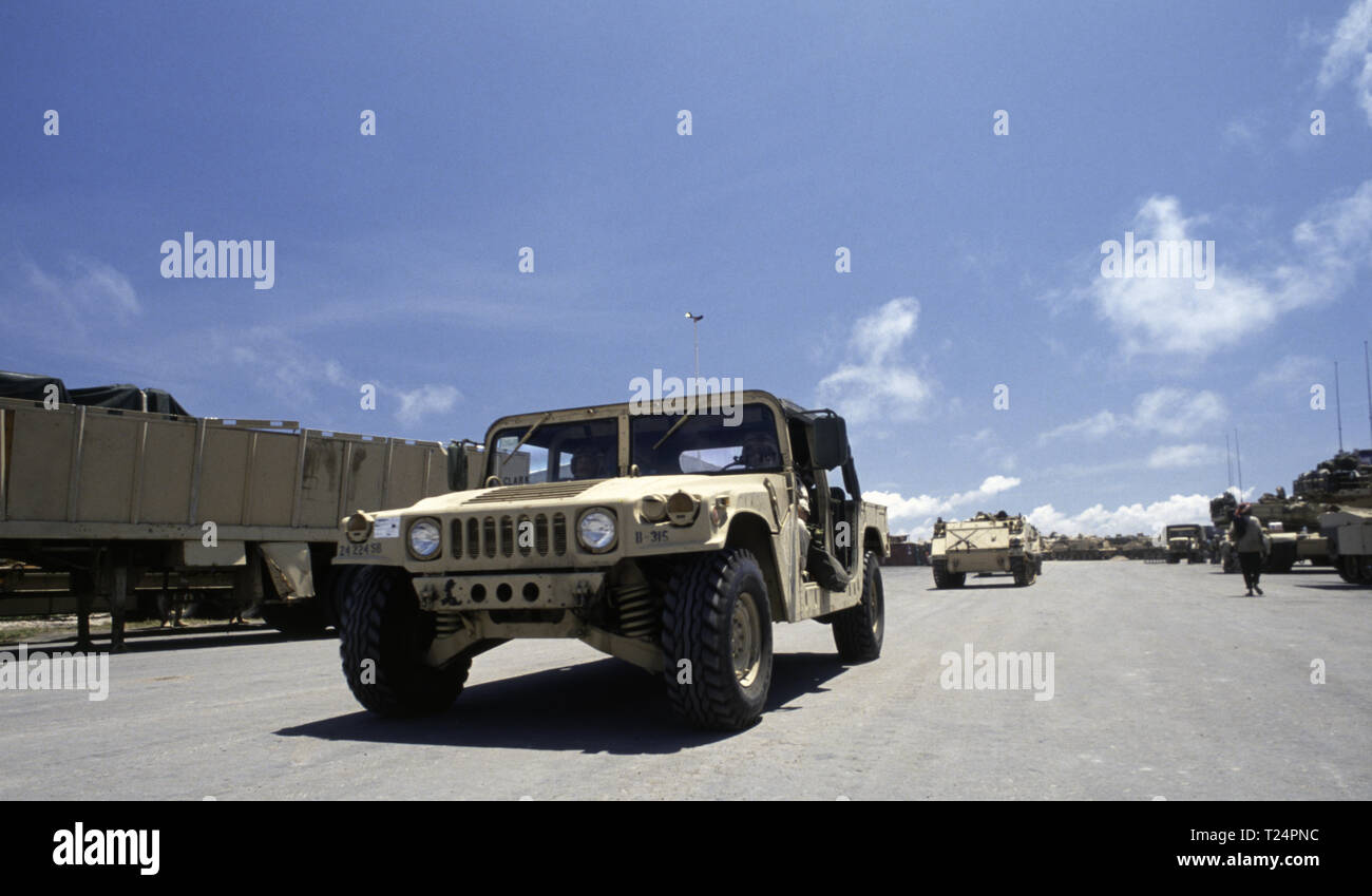 30th October 1993 A U.S. Army Humvee followed by M113 APCs that have just arrived by sea in the new port in Mogadishu, Somalia. On the right are M1A1 Abrams tanks, also unloaded early that morning. Stock Photo