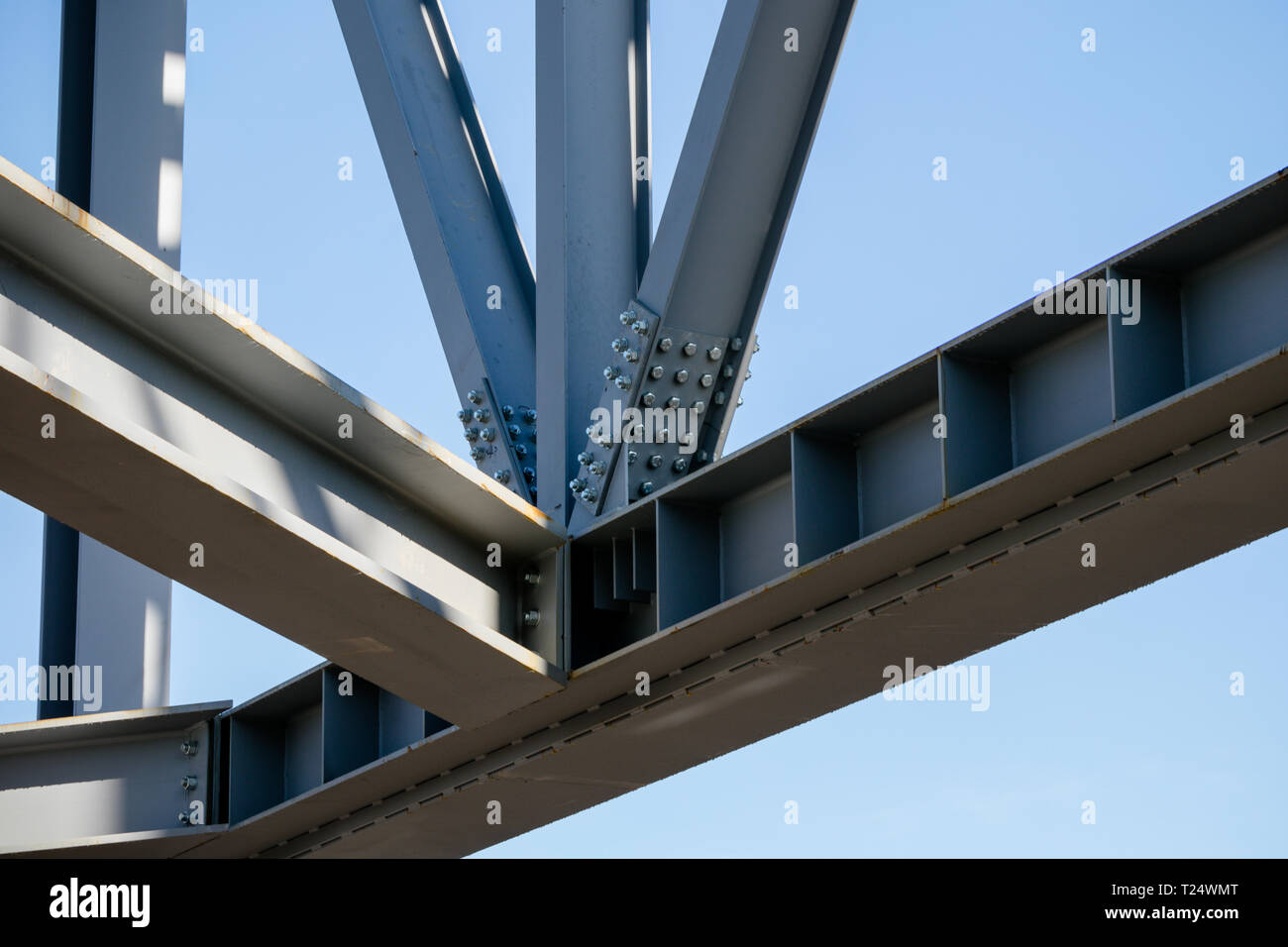 Steel frame of new building in construction set against bright blue sky Stock Photo