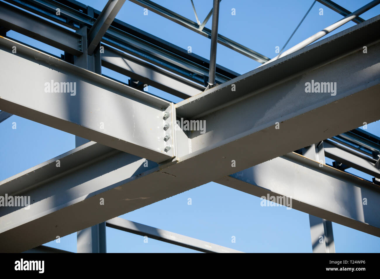 Steel frame joint detail of new building in construction set against bright  blue sky. Close up Stock Photo - Alamy