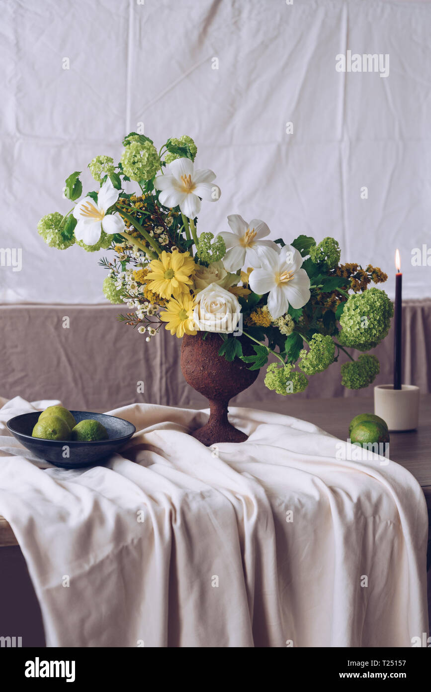 Still life with a beautiful bouquet of flowers, candles and limes Stock ...