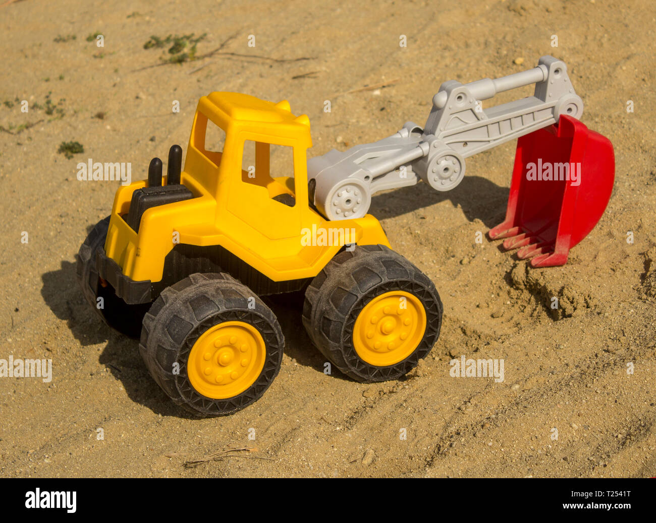 Yellow excavator toy in sand, on the beach. Boy's toys concept - Image ...