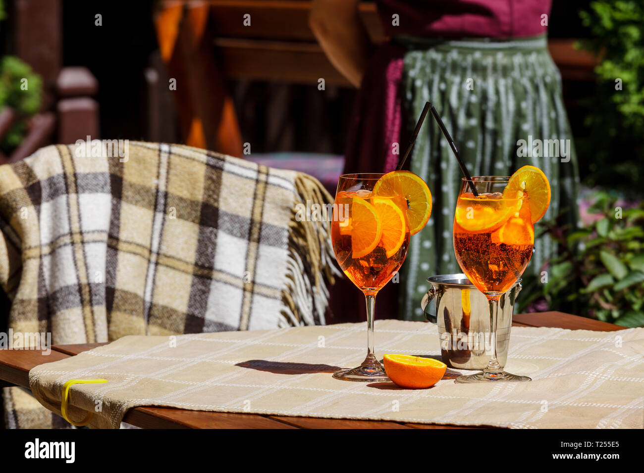 Aperol spritz cocktail in glass on the wooden table against a bright ...