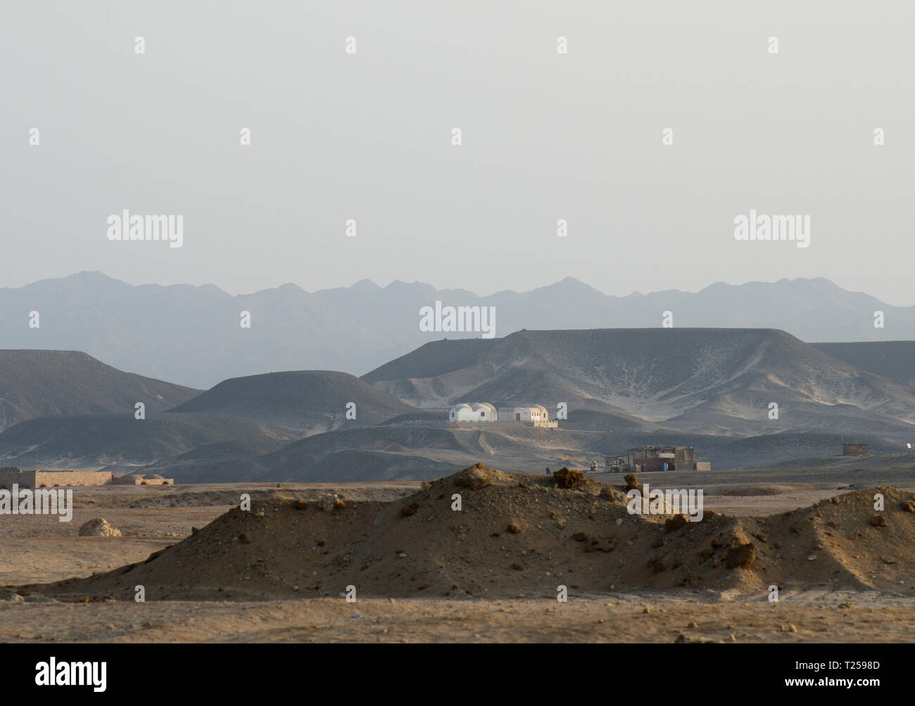 Desert view with small dwellings and earthworks, Hamata, Egypt Stock Photo