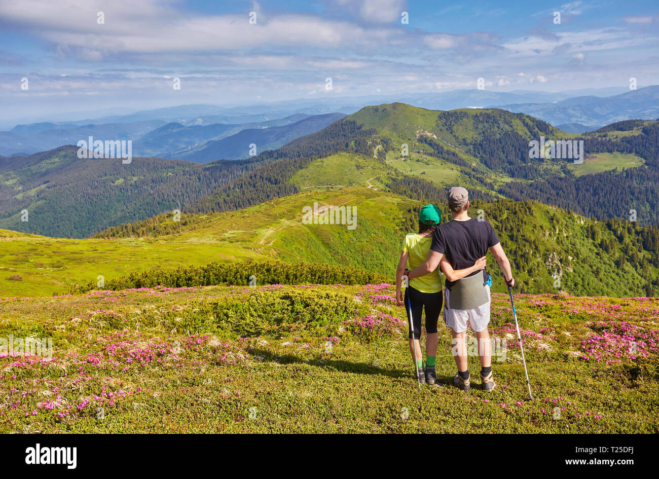 Man and woman standing and hugging on the top of the mountain, summer ...