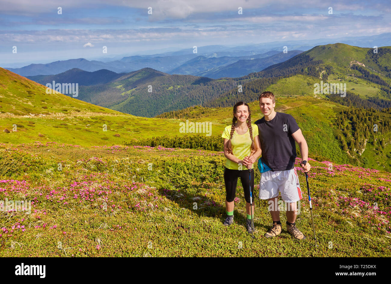 Man and woman standing and hugging on the top of the mountain, summer ...