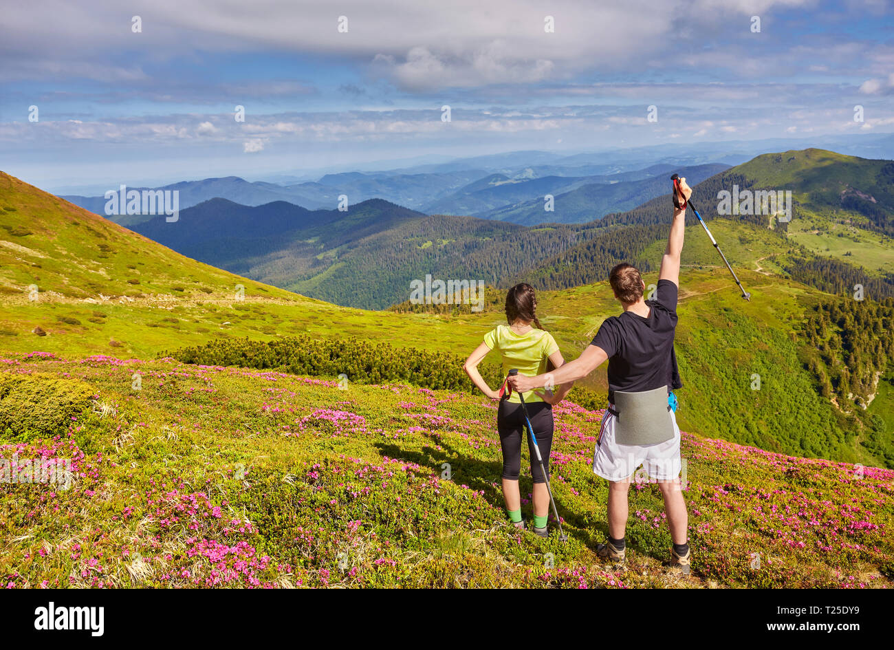 Man and woman standing and hugging on the top of the mountain, summer ...