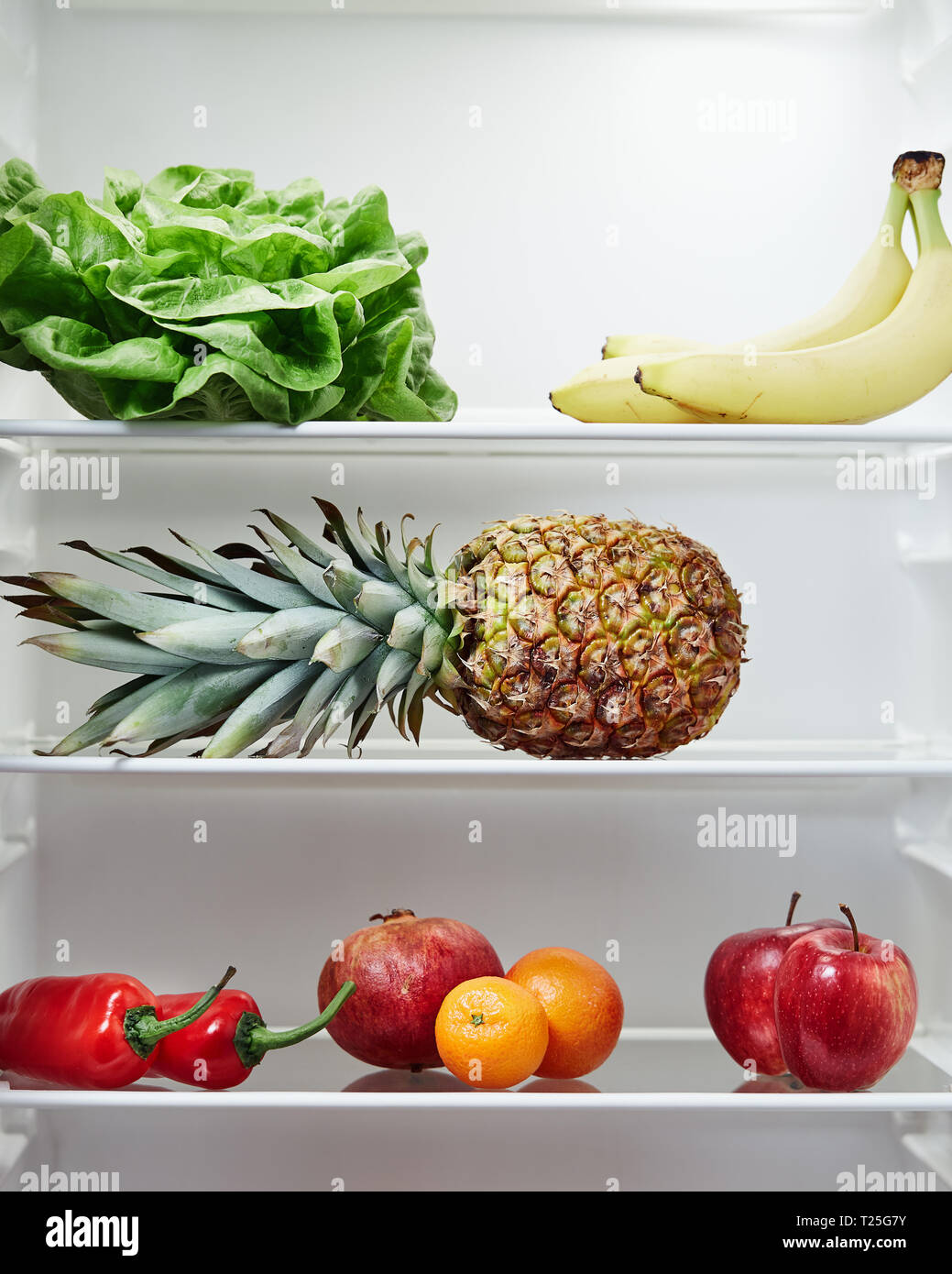 Open refrigerator containing fresh and healthy foods . Fridge filled with fruit and vegetables. Stock Photo
